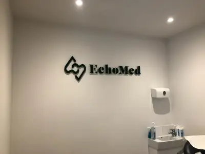 Black EchoMed built-up logo lettering and symbol mounted on a white clinic wall
