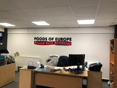 Foods of Europe British Food Worldwide navy and red wall sign above a cluttered office desk