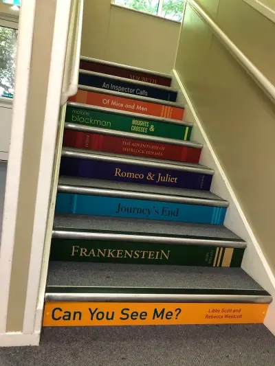 Stair risers wrapped as book spines including Frankenstein, Romeo & Juliet and Journey's End