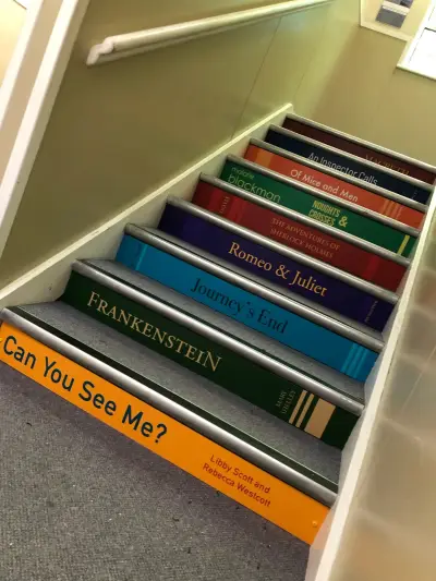 Staircase risers printed as classic book spines including Macbeth, Of Mice and Men and Frankenstein