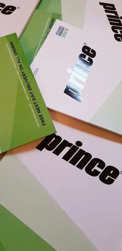 Green and white printed Prince brand brochures with Frameworksports branding fanned on a surface