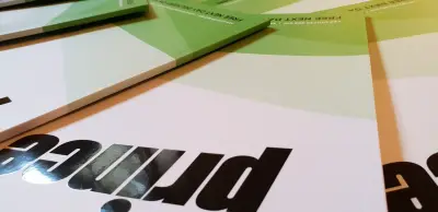 Close-up of printed Prince brochure covers with foil and gloss black logos