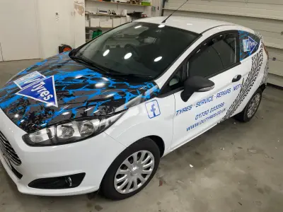 White Ford Fiesta van part-wrapped for 2U Tyres with blue graphics and Tyres Service Repairs MOTs text