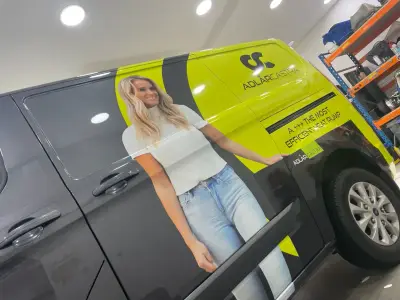 Grey and lime-green van wrap for Adlar Castra with a woman graphic and heat pump message