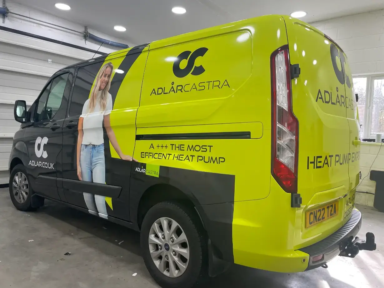 Bright yellow and black commercial van wrap for Adlarcastra heat pump company, featuring woman portrait and branding
