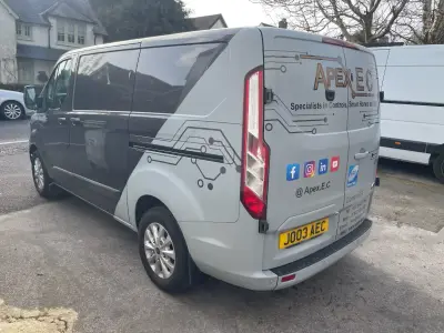 Silver Ford Transit Custom van, Apex EC part wrap, rear side angle with circuit graphics