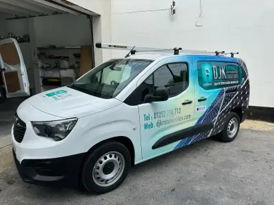 White Vauxhall Combo van, full wrap for DJK Renewables solar installers, front-side solar-panel graphics