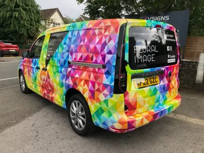 Floral Image rainbow VW Caddy van, full wrap, rear left with black window graphics