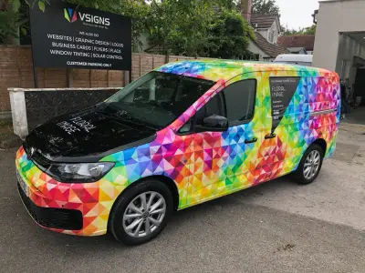 Floral Image rainbow VW Caddy van, full wrap, front left beside VSIGNS board