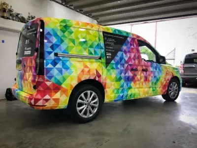 Floral Image rainbow VW Caddy van, full wrap, offside rear angle inside workshop