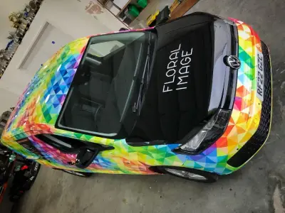 Overhead view of Floral Image VW Caddy van, gloss black bonnet and rainbow geometric body wrap