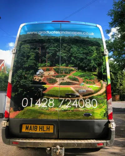 Rear of Ford Transit van with Graduate Landscapes garden photo wrap and phone number