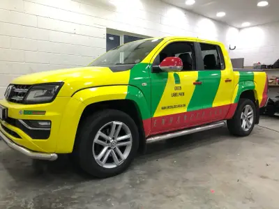 Green Label PHEM VW Amarok pickup in yellow, green and red medical-style full wrap livery