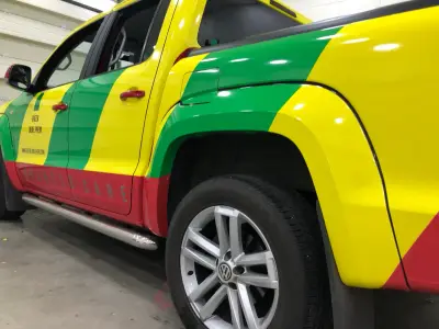 Lower side and wheel of Green Label PHEM pickup in green, yellow and red full wrap
