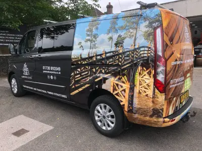 Offside of grey Green Oak Carpentry Ford Transit Custom van with oak-frame photo wrap and details