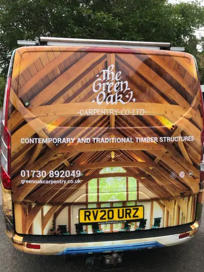 Rear of Green Oak Carpentry van, timber-frame roof photo wrap with logo and contact details