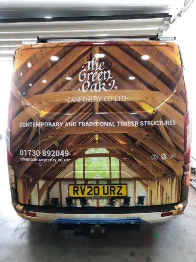Rear of Green Oak Carpentry van wrapped with oak timber-frame roof photograph and phone number