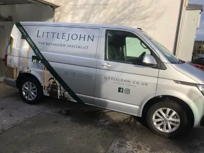 Nearside of silver Littlejohn Bathroom Specialist VW Transporter with large signwriting and contact details