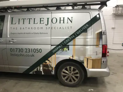 Offside of silver VW Transporter with Littlejohn The Bathroom Specialist signwriting and part wrap