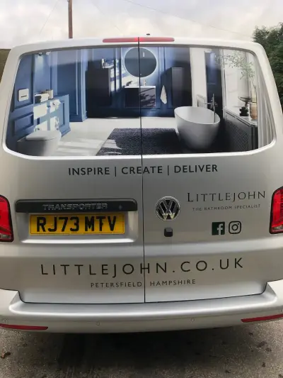 Rear of silver Littlejohn VW Transporter, rear windows wrapped with a blue bathroom scene