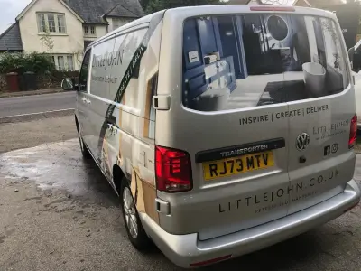 Rear passenger angle of silver Littlejohn Bathroom Specialist VW Transporter with window graphics