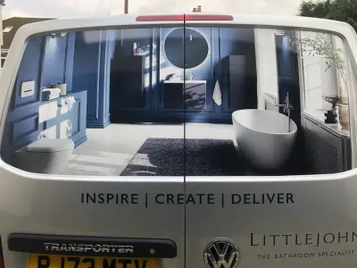 Rear of silver Littlejohn VW Transporter with blue bathroom window graphics and Inspire Create Deliver text