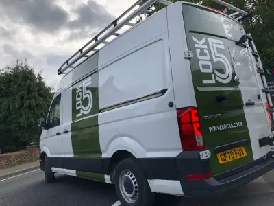 Rear offside of white VW Crafter van with green Lock5 vertical stripe part wrap and logo