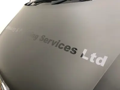 Close-up of matte grey van bonnet signwriting reading NB Heating & Plumbing Services Ltd