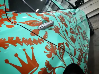 Turquoise Kia Picanto with Silent Pool Gin floral wrap, rear quarter view