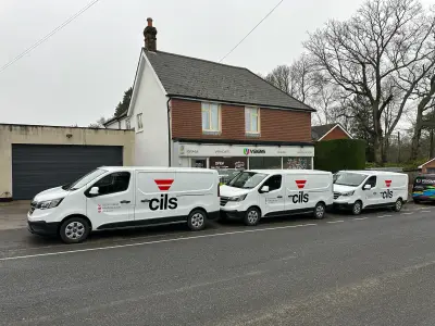Fleet of three white cils Renault Trafic vans with red and black logo graphics outside the V Signs shop