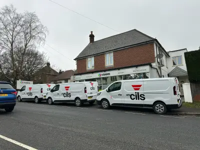Three cils-branded white Renault Trafic fleet vans with red and black vinyl graphics outside the V Signs shopfront