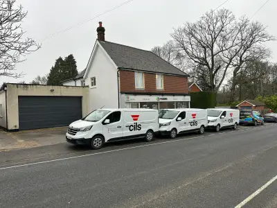 Three white cils fleet vans with vehicle graphics and a wrapped V Signs van outside the signage shop