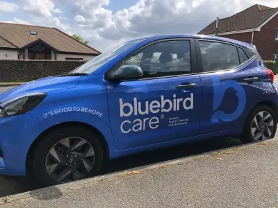 Driver side of blue Hyundai i10 with Bluebird Care Ipswich full wrap and bird logo