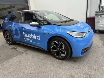 Blue VW ID.3 hatchback front quarter with Bluebird Care full wrap by V Signs sign