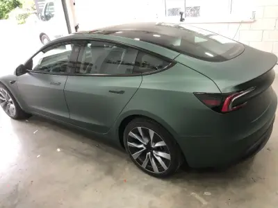 Completed matt metallic pine green colour-change wrap on a Tesla Model S, rear quarter view
