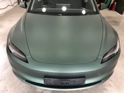 Matt metallic pine green full wrap on a Tesla Model S, front view in the workshop