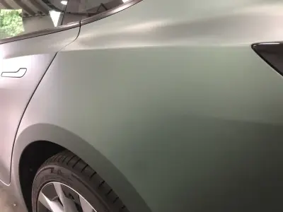 Close-up of matt metallic pine green colour-change vinyl on a Tesla Model S rear wing