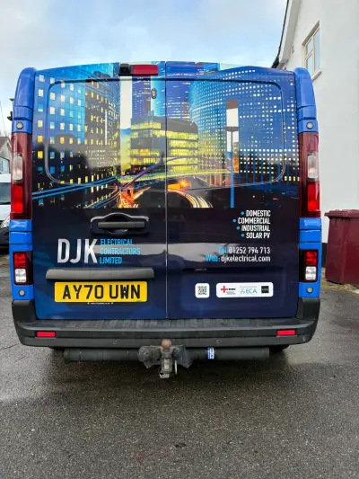 Rear doors of DJK Electrical Contractors blue van wrap with night cityscape graphics
