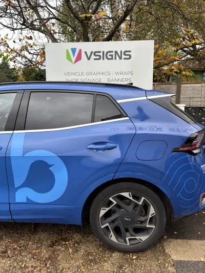Blue Kia Sportage rear quarter with Bluebird Care bird logo wrap by V Signs sign