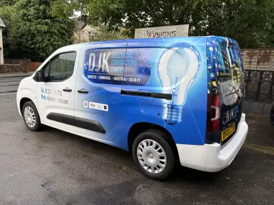 White and blue compact van, DJK Electrical Contractors full wrap with glowing lightbulb