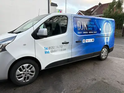 White and blue Renault Trafic van with DJK Electrical Contractors part wrap and lightbulb