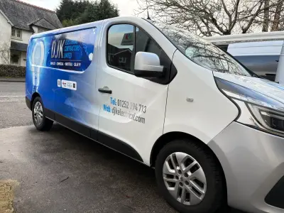 Silver Renault Trafic van side with DJK Electrical Contractors part wrap and lightbulb
