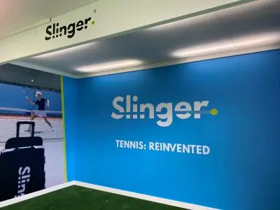 Printed blue Slinger 'Tennis: Reinvented' event backdrop wall and fascia sign at tennis exhibition
