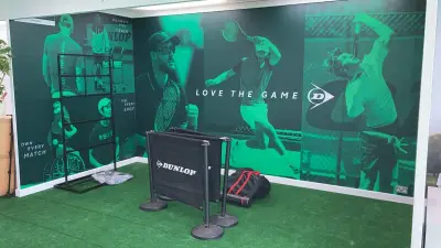 Dunlop exhibition backdrop wall printed with green player graphics and 'Love the Game' slogan