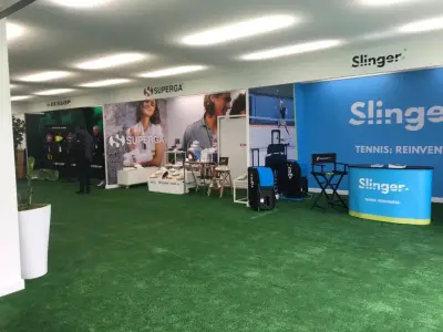 Exhibition hall with printed Dunlop, Superga and Slinger stand graphics and fascia signs on artificial grass
