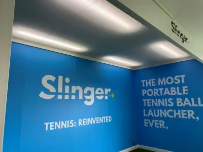 Large blue Slinger 'Tennis: Reinvented' wall graphics wrapping a corner at tennis exhibition