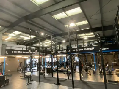 Industrial gym interior with printed black motivational quote wall boards and AM branding