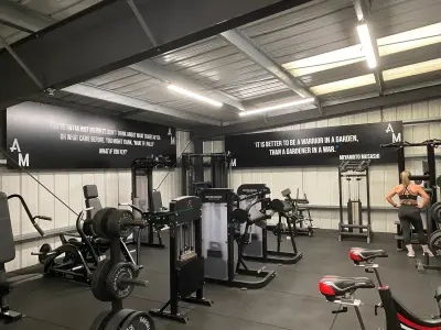 Gym floor with printed black quote wall panels, Miyamoto Musashi warrior quote and AM logos