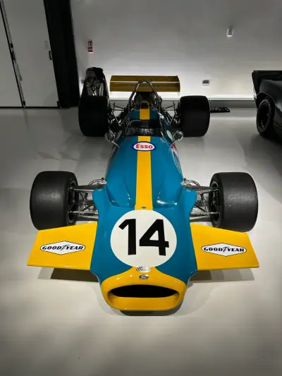 Front view of teal and yellow F1 car number 14 with yellow nose and Goodyear front wings