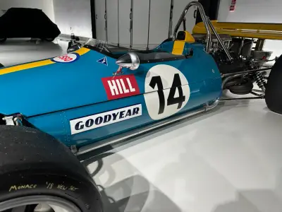 Close-up of teal F1 car flank with black 14 roundel, red Hill and Goodyear decals
